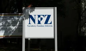 Tablica z logo NFZ i napisem Narodowy Fundusz Zdrowia. Obok tablica z informacjami o inwestycjach, jak sprawdzić oddział NFZ.