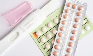 Test ciążowy i opakowania tabletek antykoncepcyjnych. Pytanie: czy podczas brania tabletek antykoncepcyjnych jest owulacja?