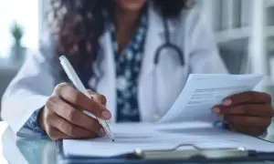 Lekarka pisze skierowanie do specjalisty. Ważność skierowania do specjalisty jest kluczowa dla dalszego leczenia.
