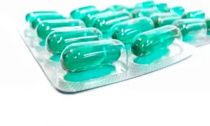 Blister opakowania z zielonymi kapsułkami, które mogą być lekiem Inflanor Max.