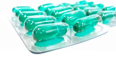 Blister opakowania z zielonymi kapsułkami, które mogą być lekiem Inflanor Max.