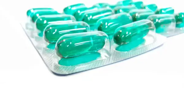 Blister opakowania z zielonymi kapsułkami, które mogą być lekiem Inflanor Max.