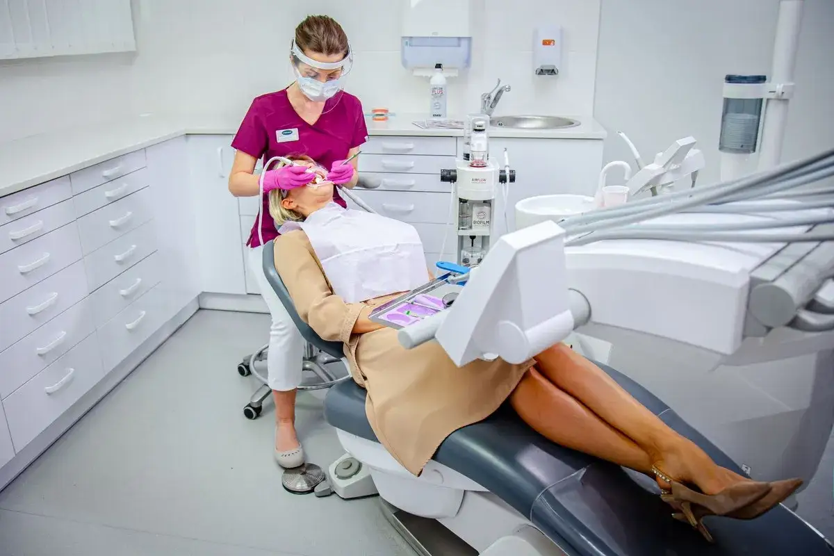Stomatologia Lindleya NFZ: pacjentka na fotelu dentystycznym, higienistka wykonuje zabieg.