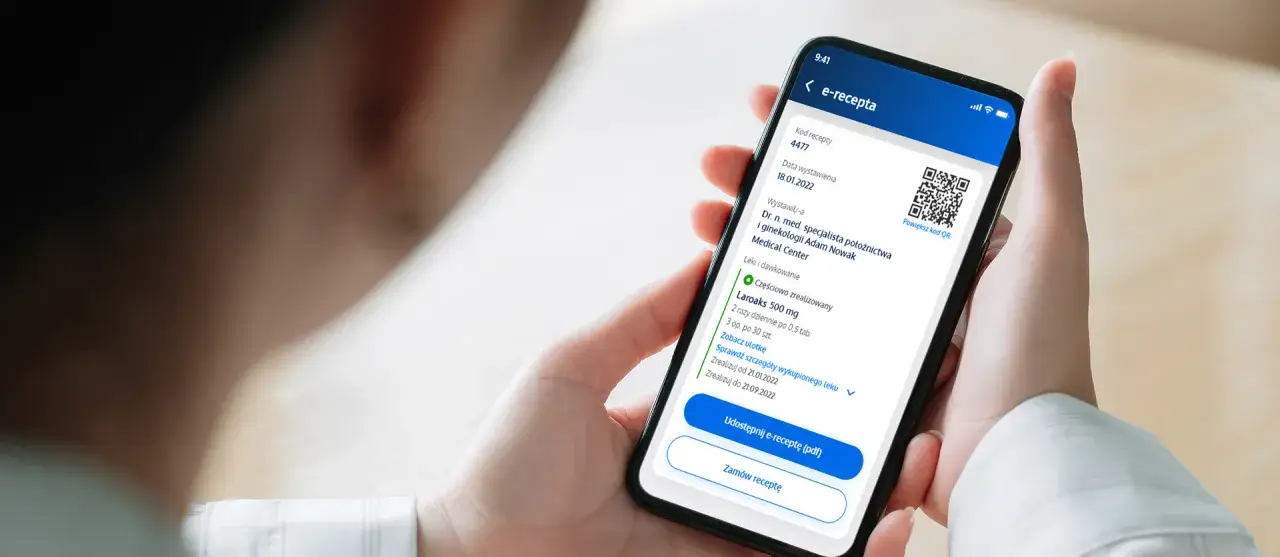 Osoba trzyma smartfon z e-receptą. Czy lekarz NFZ widzi prywatne recepty? Aplikacja pokazuje szczegóły leku i datę wystawienia.