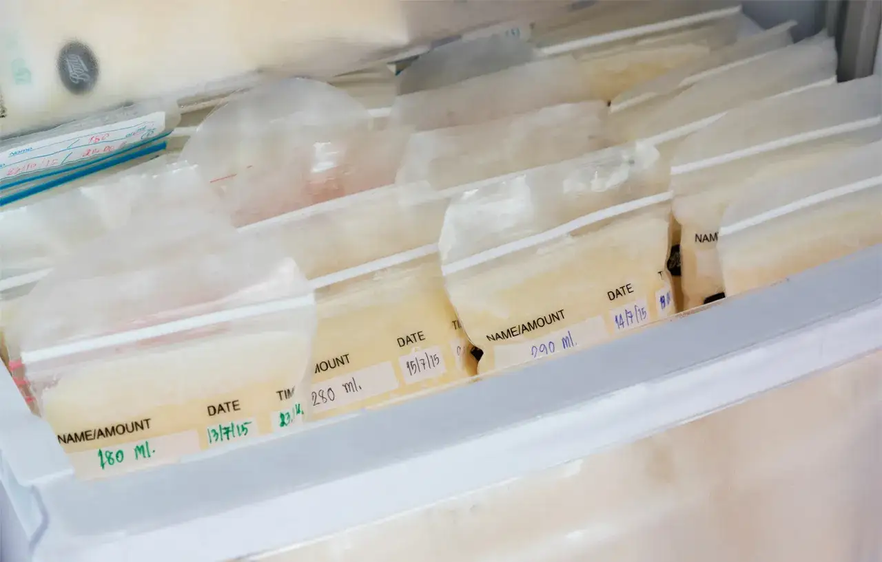W zamrażarce przechowywane są woreczki z mlekiem matki. Na etykietach widać daty i ilości, co pomaga śledzić, ile może stać rozmrożone mleko matki.